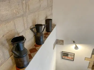 three black vases sitting on a shelf next to a brick wall at Nelle Antiche Mura in Castellammare del Golfo