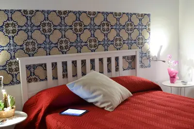 a bedroom with a red bed with a red blanket at B&B Ponticello in Palermo