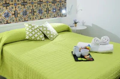 a green bed with a tray of towels and towels at B&B Ponticello in Palermo