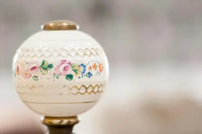 a white vase with flowers on a gold stand at B&B Ponticello in Palermo