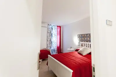 a bedroom with a red bed and a red window at B&B Ponticello in Palermo