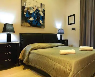a bedroom with a bed and a painting on the wall at Corsovittorio111 in Palermo
