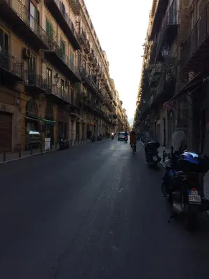 an empty street with motorcycles parked on the sides of buildings at Corsovittorio111 in Palermo