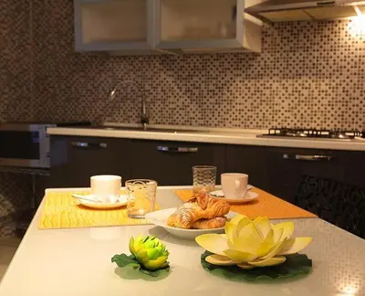 a kitchen table with a plate of food and flowers on it at Corsovittorio111 in Palermo