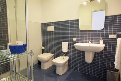 a blue tiled bathroom with a toilet and a sink at B&B Kolors in Castellammare del Golfo