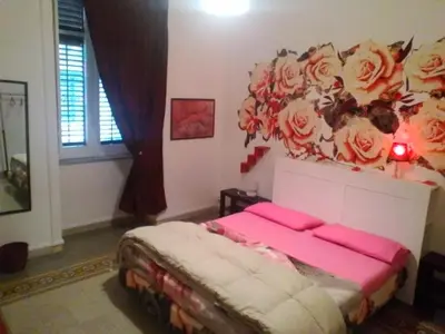 a bedroom with a bed with roses on the wall at Palermo Centrale in Palermo