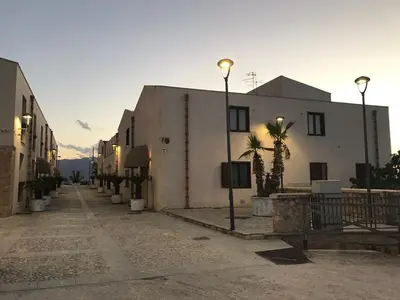 a street with buildings and palm trees and street lights at Marina Holiday Hotel & Spa in Balestrate