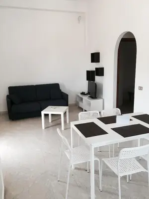 a living room with a couch and a table and chairs at Residence Guidaloca in Scopello