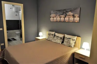 a bedroom with a bed with two lamps and a mirror at casa Francy in San Vito lo Capo
