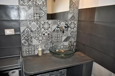 a bathroom with a bowl sink and a tiled wall at casa Francy in San Vito lo Capo