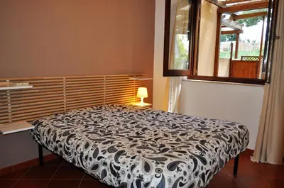 a bedroom with a bed with a black and white comforter at casa Francy in San Vito lo Capo