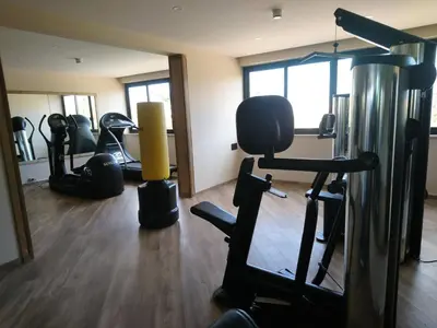 a gym with several treadmills and exercise equipment at San Paolo Palace Hotel in Palermo