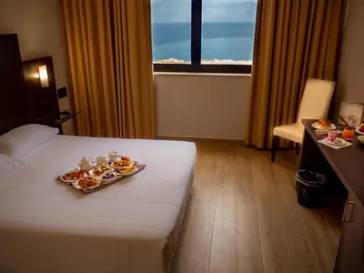 a hotel room with a tray of food on a bed at San Paolo Palace Hotel in Palermo