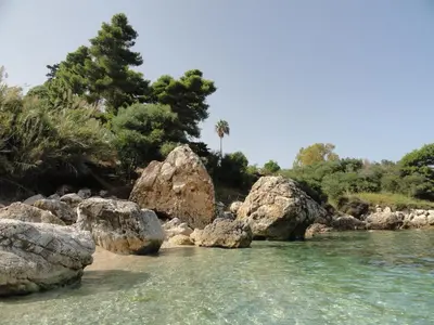 a river with rocks in the water and trees at Piccola Baia in Scopello