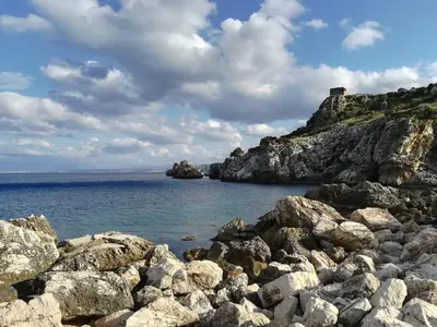 a rocky shore with a castle on top of it at Piccola Baia in Scopello