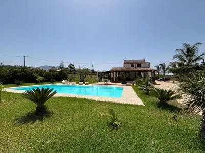 a swimming pool in a yard with a house in the background at Villa delle Cecilie in Partinico