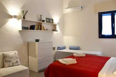 a bedroom with two beds and a red blanket at Villa Tramonto in Macari