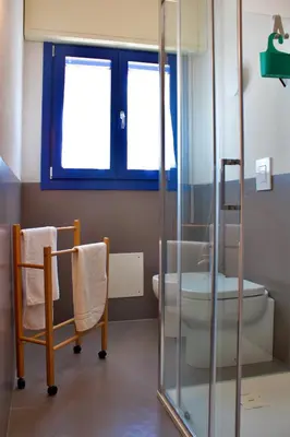 a bathroom with a toilet and a glass shower at Villa Tramonto in Macari