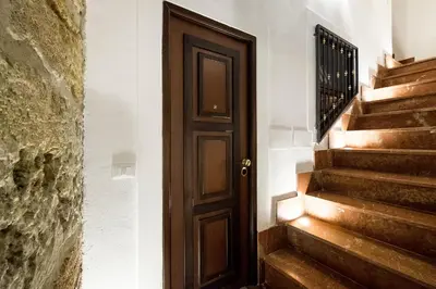 a wooden door in a hallway with stairs at Casa Petra ai Quattro Canti in Palermo