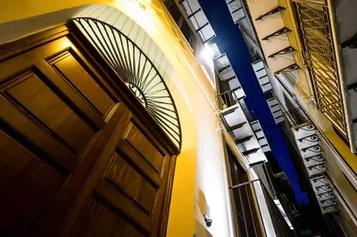 a wooden door in a building with a spiral staircase at Casa Petra ai Quattro Canti in Palermo