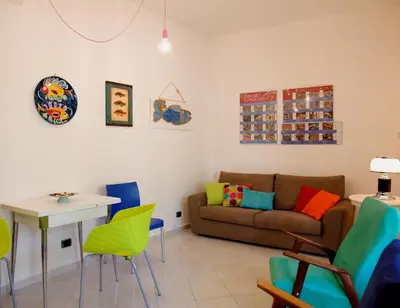 a living room with a couch and a table and chairs at Siciliaiu in Mondello