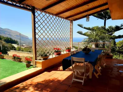 a blue table and chairs on a patio with a view at Lomarchi Holiday Home in Carini