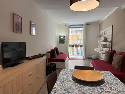 a living room with a flat screen tv and a table at Casa Ranieri Palermo in Palermo
