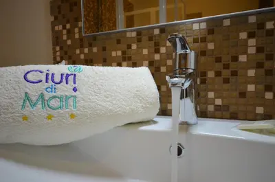a roll of paper towels sitting on a bathroom sink at Ciuri Di Mari in San Vito lo Capo