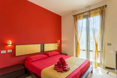 a red bedroom with a bed with a red wall at Karma B&B in San Vito lo Capo