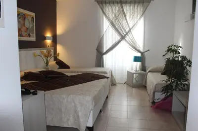 a bedroom with two beds and a window at Artemisia Palace Hotel in Palermo