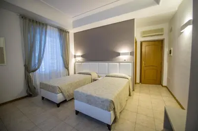 a hotel room with two beds and a window at Artemisia Palace Hotel in Palermo
