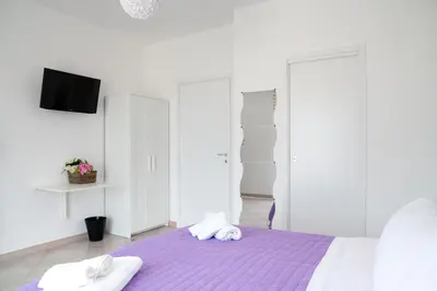 a white bedroom with two towels on a bed at Sui tetti b&b in Alcamo