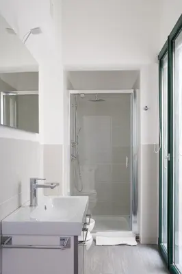 a white bathroom with a sink and a shower at Sui tetti b&b in Alcamo