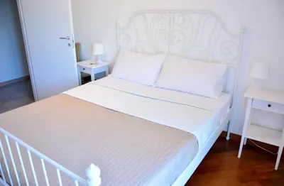 a white bed with a white headboard in a bedroom at Sui tetti b&b in Alcamo