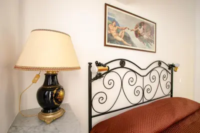 a lamp sitting on a table next to a bed at Appartamento Piazza Pretoria in Palermo