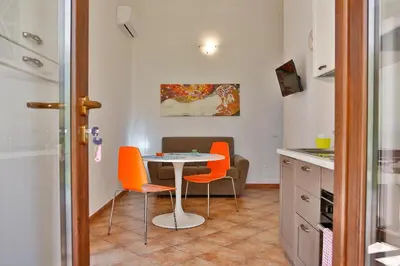 a small kitchen with a table and orange chairs at Verdemare in Cefalù