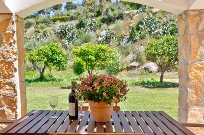 a table with a bottle of wine and a plant at Verdemare in Cefalù
