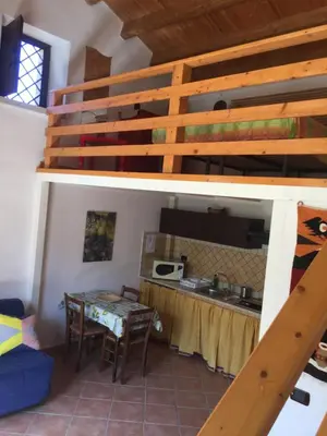 a loft bed in a room with a table at Lovely Cottage in Castellammare del Golfo