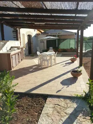 a patio with a table and chairs under a pergola at Lovely Cottage in Castellammare del Golfo