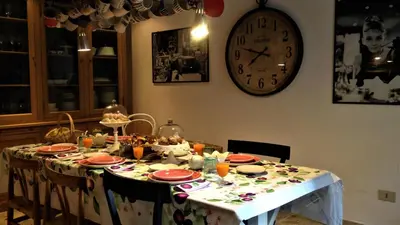 a dining room table with a clock on the wall at A Casa di Amelie in Palermo
