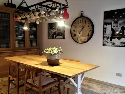 a dining room table with a clock on the wall at A Casa di Amelie in Palermo