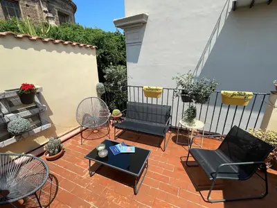 a patio with chairs and tables and a fence at BB4U Apartments and Terrace in Palermo