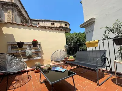 a patio with chairs and a table on a balcony at BB4U Apartments and Terrace in Palermo