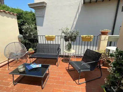 a patio with chairs and tables and a fence at BB4U Apartments and Terrace in Palermo