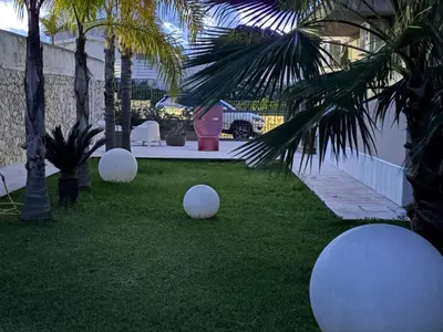 a yard with white balls on the grass with palm trees at Villa Ruffino in Balestrate