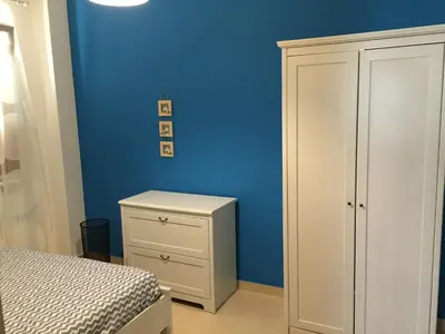 a bedroom with a white cabinet and a blue wall at Villa Ruffino in Balestrate