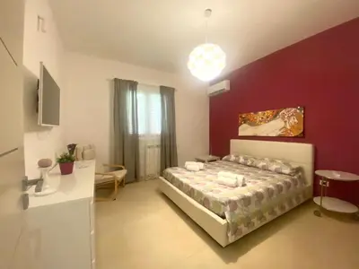 a bedroom with a bed and a purple wall at Villa Ruffino in Balestrate