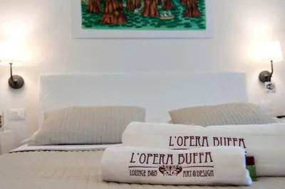 a white bed with two pillows on top of it at L'Opera Buffa in Palermo