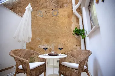 a small table with two chairs and a umbrella at Case di Maria in Castellammare del Golfo
