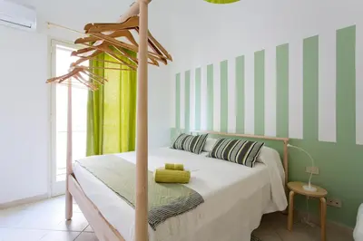 a bedroom with a bed with green and white stripes at Oasi Centrale in Palermo